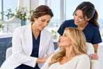 Doctor and team member warmly welcoming a patient in the clinic.